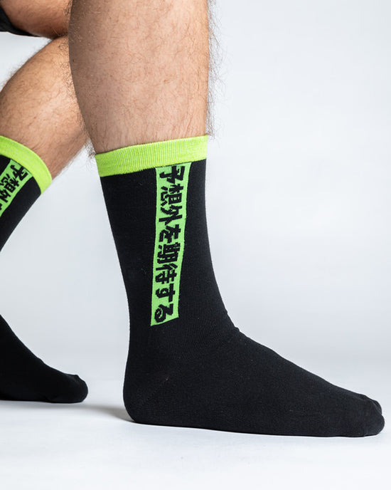A pair of black socks with neon inlays and the Ninjas in Pyjamas logo from NIP merch collection. These comfortable and stylish socks are designed to represent your passion for NIP while adding a touch of ninja-inspired flair to your everyday outfit.