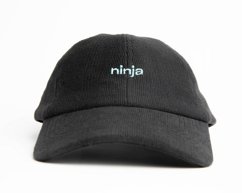 A black ninja cap from the NIP X Stiksen merch collaboration, featuring the Ninjas in Pyjamas logo subtly embroidered on the front. This stylish and adjustable cap is perfect for showcasing your support for NIP in a sleek and trendy way.